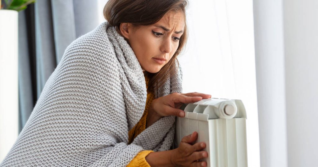 worried woman holding heater