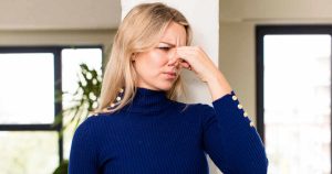 woman holding her nose